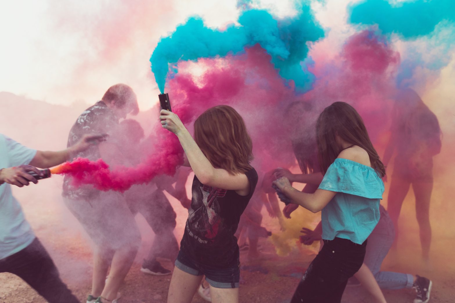 Middle school kids playing with pink and blue color powder.
